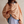 Vrouw in oversized gestreepte trui en blauwe shorts, casual mode, comfortabele kleding, trendy dameskleding, modieuze outfit, ontspannen stijl.