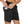 Man in zwarte sportshorts met telefoon in zijzak, elastische tailleband, geschikt voor hardlopen en fitness. Comfortabele en functionele sportkleding.