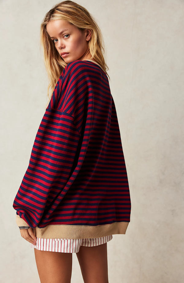 Jonge vrouw in oversized rood-blauw gestreepte trui en gestreepte shorts, modeportret, casual kleding, herfststijl, trendy damesmode.