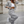 Grijze gestreepte damespak met wijde broek en cropped blazer, gecombineerd met een wit topje en sneakers. Modieuze zakelijke outfit voor dames.