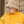 Man met beige teddy bucket hat en zonnebril, draagt een gele jas. Stijlvolle wintermode, trendy accessoires, buitenkleding.