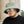 Man met groene teddy bucket hat en spiegelzonnebril, casual zwarte trui, buitenomgeving. Modieuze herenkleding, trendy accessoires.