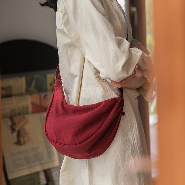 Vrouw met rode schoudertas, casual outfit, binnenshuis. Stijlvolle damesmode, trendy accessoires, moderne handtas, comfortabele kleding.