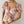 Vrouw draagt roze bloemen crop top met vlindermotief en pofmouwen, gecombineerd met parelketting. Elegante zomermode, trendy dameskleding.