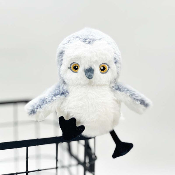 Pluche sneeuwuil knuffel met zwarte poten en gele ogen, zittend op een metalen kooi. Perfect speelgoed voor kinderen, zachte en schattige uil knuffel.