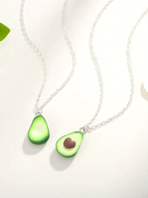 Twee zilveren kettingen met avocado-hangers, één met hartvormige pit. Perfecte sieraden voor avocado-liefhebbers, trendy en uniek ontwerp.