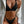 Vrouw in zwarte bikini met witte blazer, modieuze strandkleding, stijlvolle badmode, zomeroutfit, elegante damesmode.