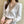 Elegante witte blouse met V-hals en geborduurde details, gedragen door een vrouw. Perfect voor zakelijke en casual outfits. Stijlvolle damesmode.