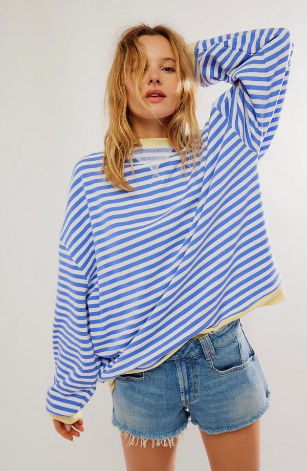 Jonge vrouw in blauw-wit gestreepte trui en denim shorts, casual mode, trendy dameskleding, comfortabele outfit, streetwear stijl.