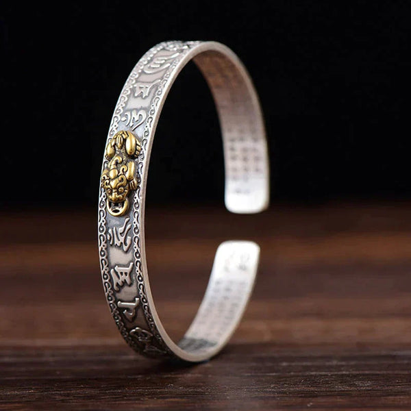 Zilveren armband met gouden leeuwenkop en Tibetaanse inscripties, handgemaakt sieradenontwerp, boeddhistische symboliek, unisex accessoire.