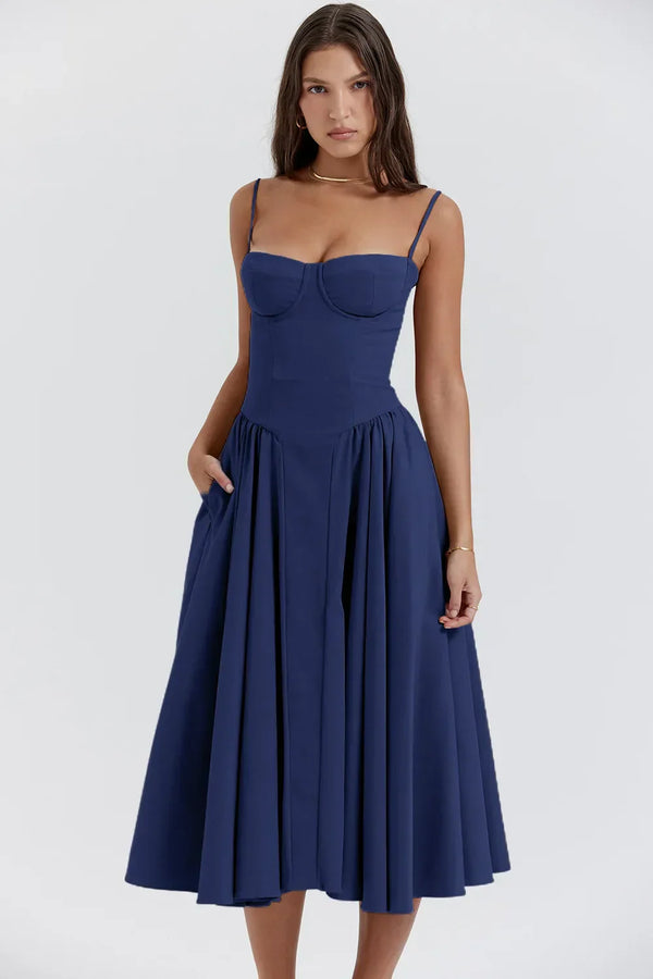 Vrouw in elegante blauwe midi-jurk met spaghettibandjes, perfecte zomeroutfit. Stijlvolle mode voor dames, casual en chic.