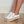 Witte dames sneakers met kurkzool, veters en zilveren details op houten vloer. Modieuze casual schoenen voor dagelijks gebruik.