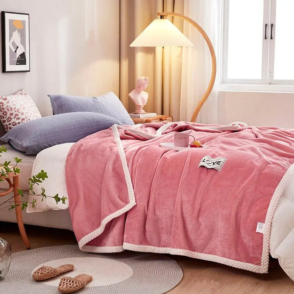 Roze fleece deken op bed in moderne slaapkamer, met sierkussens en vloerlamp. Gezellige en stijlvolle inrichting voor comfortabele nachtrust.