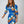 Vrouw in kleurrijke, gestreepte jurk met blauwe, oranje en witte patronen, modieuze uitstraling, trendy kleding, moderne damesmode.