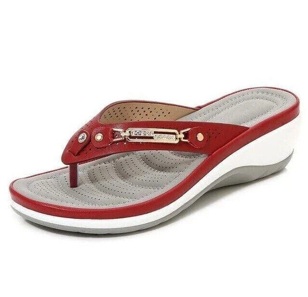 Rode dames teenslipper met verhoogde witte zool, comfortabele grijze binnenzool en decoratieve metalen details. Perfect voor zomerse casual outfits.
