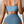 Vrouw in blauwe hoge taille bikini met ruches, gewatteerde push-up top. Trendy badmode 2024, effen kleur, sexy en stijlvol ontwerp voor dames.