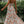 Vrouw in lange, zomerse bloemenjurk met halternek, draaiend in tuin. Elegante mode, casual stijl, perfecte outfit voor warme dagen.