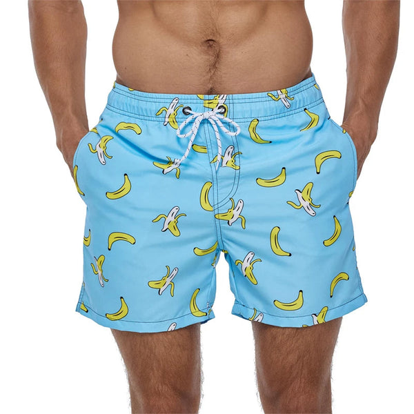 Blauwe zwembroek met bananenprint, gedragen door man. Trendy zwemkleding, zomermode, strandoutfit. Comfortabele pasvorm, levendige kleuren.