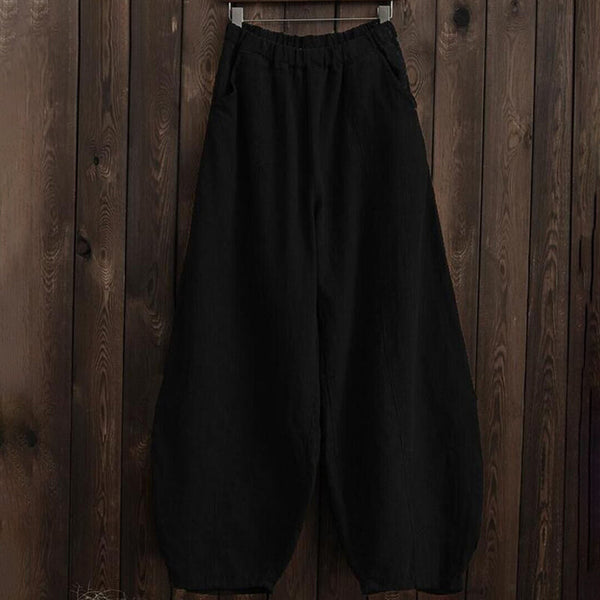 Zwarte wijde broek, hangend aan houten achtergrond, comfortabele pasvorm, casual stijl, ideaal voor dagelijks gebruik, modieuze dameskleding.
