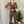 Vrouw in luipaardprint sportset maakt selfie voor spiegel, naast groene kamerplant. Fitnessmode, trendy sportkleding, thuisworkout.