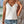 Vrouw in witte kanten top en denim shorts, sieraden, zomerse outfit, casual mode, buiten, trendy kledingstijl, boho accessoires.