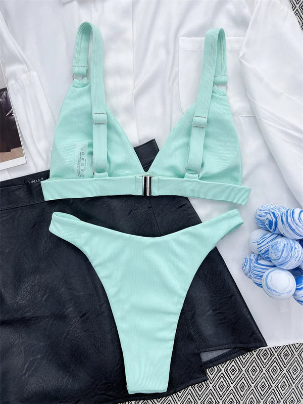 Mintgroene bikini set met verstelbare bandjes en metalen sluiting, gestyled op zwarte rok en witte blouse. Perfect voor strandmode en zomertrends.