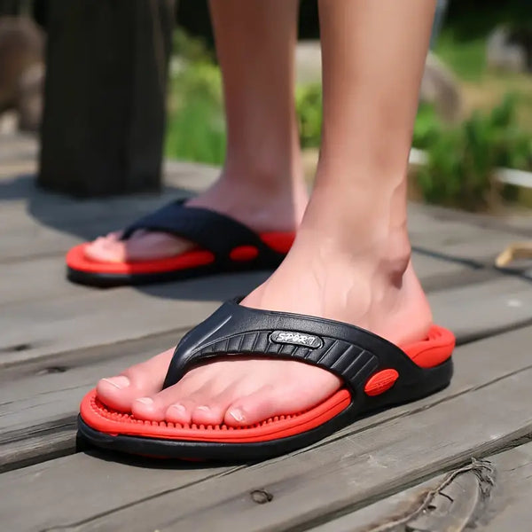 Zwarte en rode teenslippers op houten vloer, comfortabele zomerschoenen voor heren, ideaal voor strand en casual gebruik.
