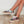Vrouwelijke benen dragen kleurrijke, gebloemde sneakers met witte veters op houten vloer. Modieuze damesschoenen, casual stijl, trendy ontwerp.