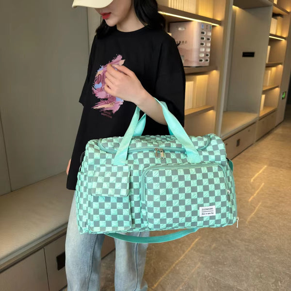 Vrouw met mintgroene geruite reistas, casual outfit, moderne winkelomgeving. Stijlvolle weekendtas, trendy modeaccessoire, praktische reisoplossing.