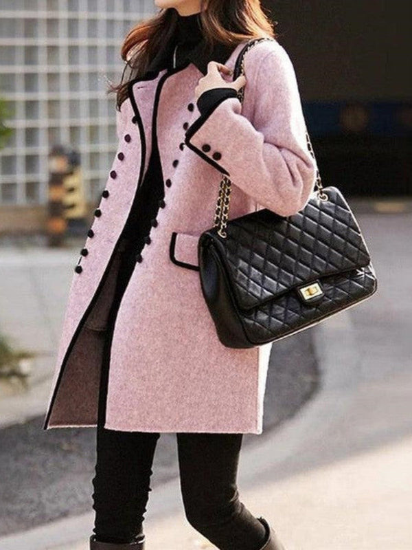 Vrouw in roze wollen jas met zwarte knopen, draagt een zwarte gewatteerde handtas met kettingriem. Stijlvolle wintermode, elegante dameskleding.