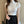 Vrouw in witte coltrui en zwarte rok, draagt een zwarte handtas en subtiele ketting. Modieuze dameskleding, elegante stijl, casual chic outfit.