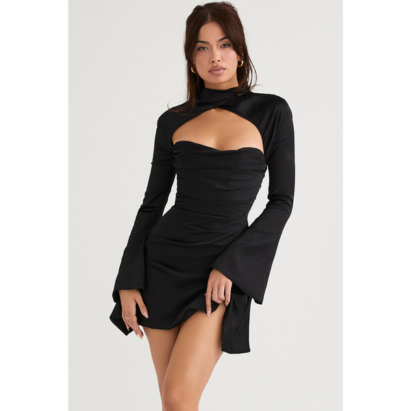 Vrouw in elegante zwarte cocktailjurk met lange mouwen en open halslijn, modieuze avondkleding, trendy damesmode, stijlvolle outfit.