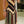 Vrouw in kleurrijke, gestreepte jurk met geometrisch patroon, staand in moderne interieur. Modieuze dameskleding, stijlvol design, trendy outfit.