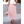 Vrouw in elegante roze tule rok en witte top, draagt een beige handtas en sandalen. Perfecte zomermode, stijlvolle outfit voor speciale gelegenheden.