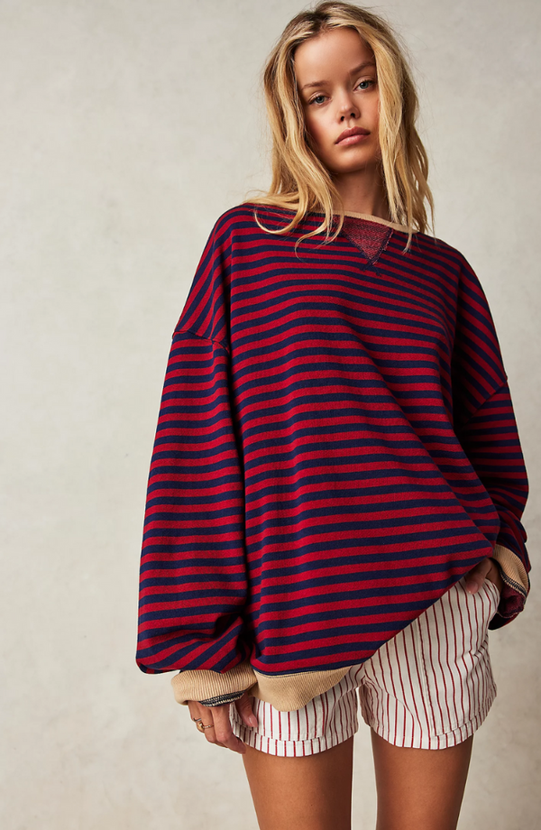 Jonge vrouw in oversized gestreepte trui en gestreepte shorts, casual mode, comfortabele kleding, herfststijl, trendy outfit, modieuze look.