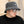 Man met grijze teddy bucket hat en zonnebril, draagt een zwart T-shirt. Stijlvolle herenkleding, trendy accessoires, casual mode.
