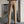 Man in beige pantalon en bruine schoenen, staand in moderne ruimte. Stijlvolle herenmode, zakelijke outfit, casual chic, modefotografie.
