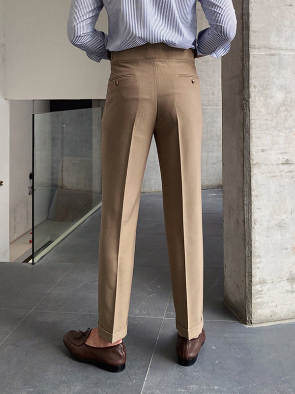 Man in beige pantalon en bruine schoenen, staand in moderne ruimte. Stijlvolle herenmode, zakelijke outfit, casual chic, modefotografie.