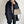 Vrouw in zwarte jas met beige handtas, draagt een grijze coltrui. Stijlvolle mode, herfstkleding, minimalistische accessoires, trendy outfit.