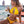 Vrouw in gele bikini drinkt cocktail op strandterras met zeezicht. Zomermode, strandkleding, vakantie, tropisch, ontspannen sfeer.