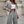 Vrouw in grijs gestreept pak met witte crop top, modieuze zakelijke outfit, trendy dameskleding, stijlvolle kantoorlook, modeaccessoires.