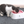 Kat drinkt water uit roze voerbak op grijze vloer. Els Pet kattenbak, modern design, geschikt voor huisdieren. Kattenaccessoires, huisdierbenodigdheden.