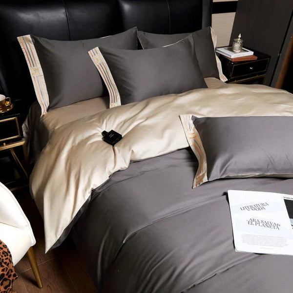 Luxe grijs en beige dekbedovertrek set op kingsize bed, met kussens en nachtkastje. Moderne slaapkamer inrichting, comfortabel en stijlvol beddengoed.