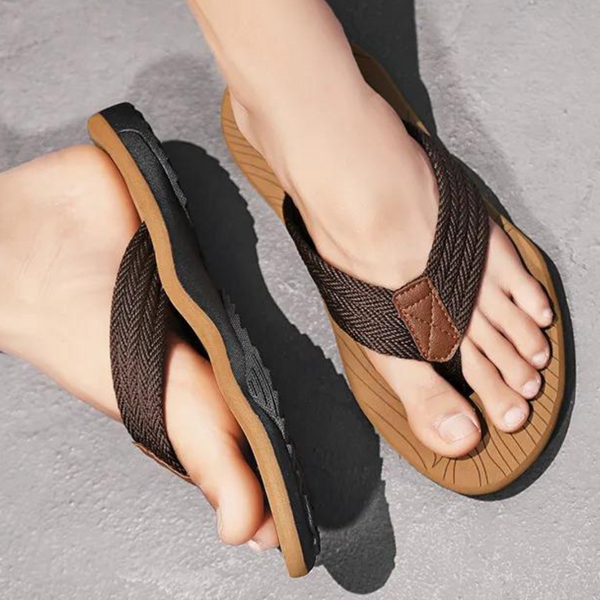 Bruine leren teenslippers voor heren op grijze achtergrond, comfortabele zomerschoenen met antislipzool, ideaal voor casual strandoutfits.