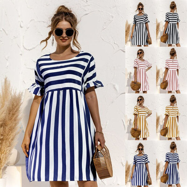 Vrouw in blauw-wit gestreepte zomerjurk met zonnebril en rieten tas, omringd door miniaturen van dezelfde jurk in verschillende kleuren.