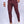 Man in bordeauxrode slim-fit broek en witte sneakers, witte blouse. Stijlvolle herenmode, casual outfit, trendy kleding voor mannen.