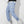 Man in blauwe cargobroek en witte sneakers, zijaanzicht. Modieuze streetwear, casual stijl, comfortabele pasvorm, geschikt voor dagelijks gebruik.