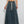 Vrouw in groene crop top en lange denim rok met witte sneakers. Trendy casual outfit, mode voor dames, streetwear stijl.
