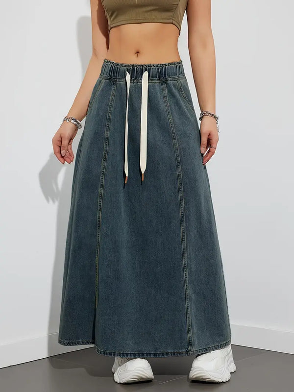 Vrouw in groene crop top en lange denim rok met witte sneakers. Trendy casual outfit, mode voor dames, streetwear stijl.
