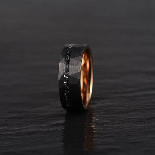 Zwart titanium herenring met roségouden binnenkant, facetten en ruwe textuur, moderne trouwring, stijlvol en duurzaam sieraad.